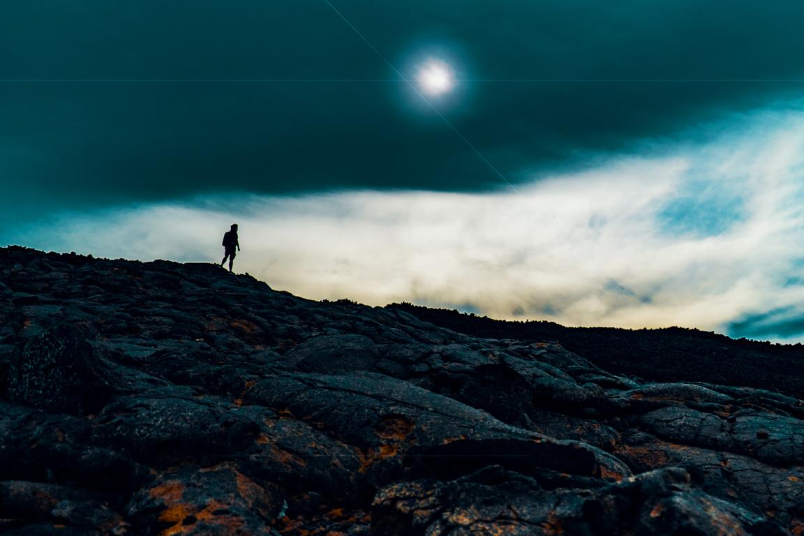 Person auf Vulkangestein Mauna Loa Hawaii